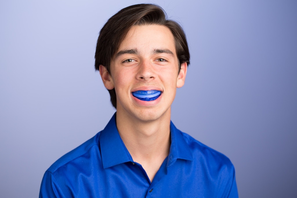 Teenage boy with a mouthguard, stressing the importance of protecting your braces and teeth.
