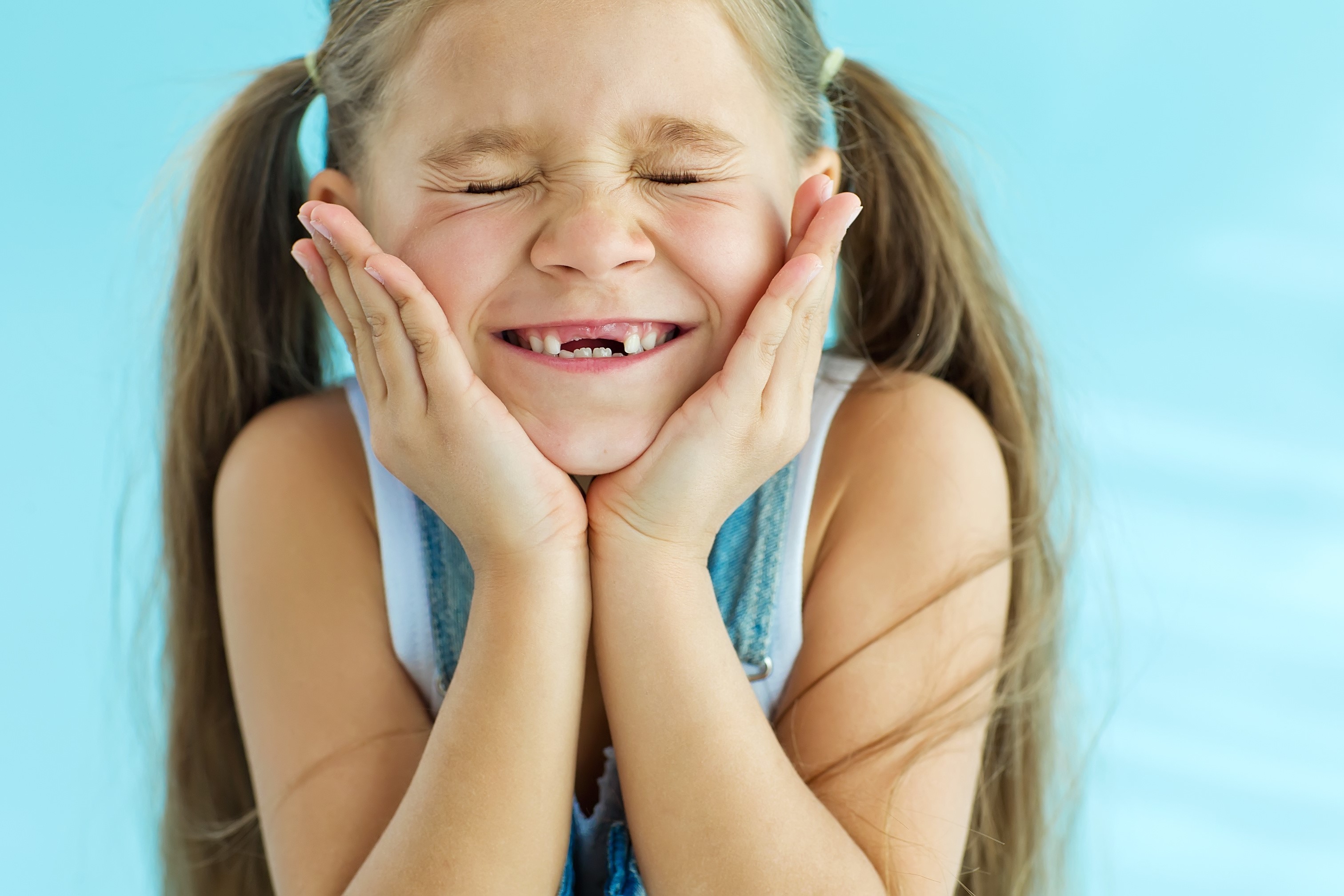 smiling young girl with missing teeth